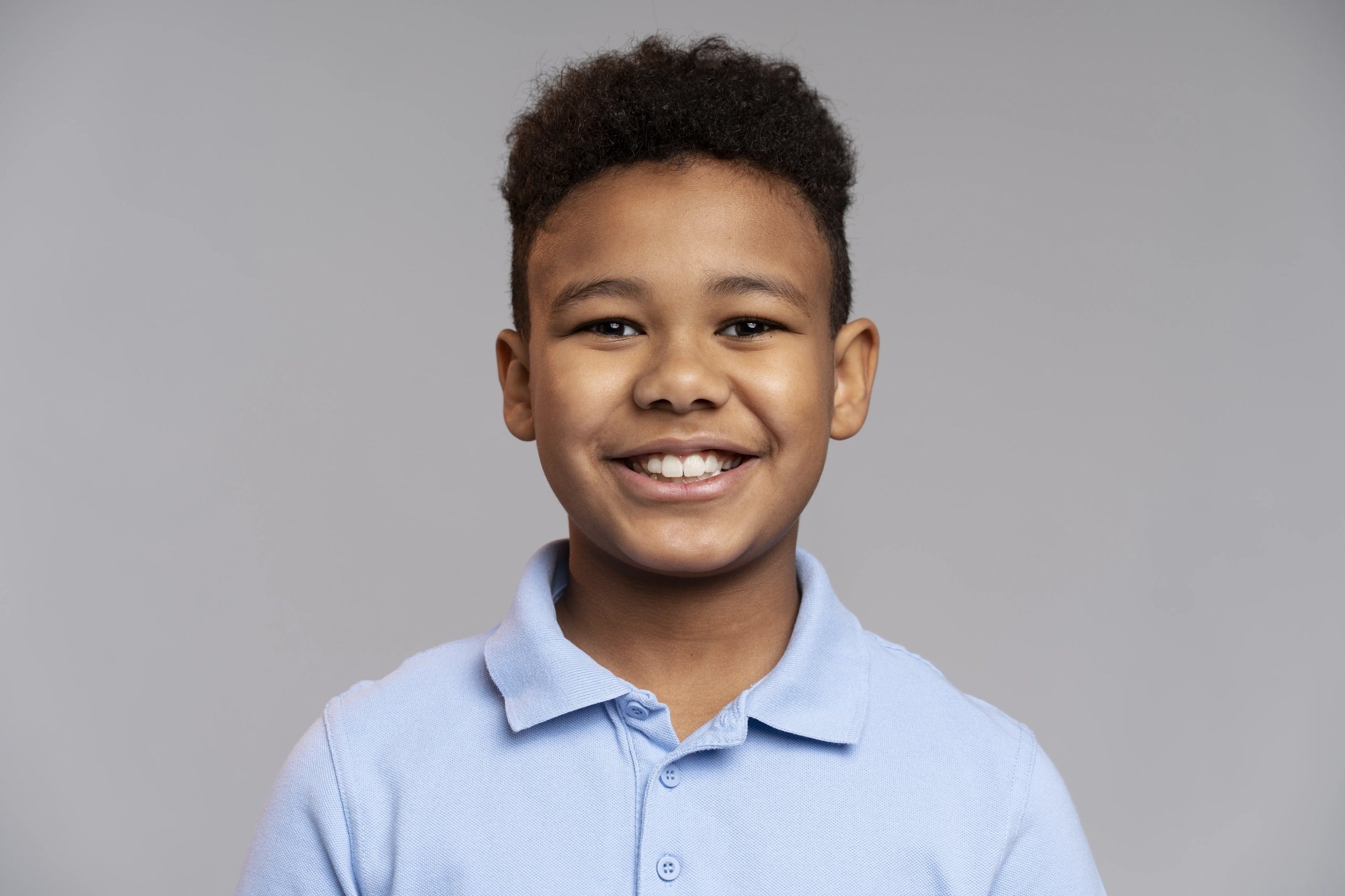 A smiling boy in a collared shirt