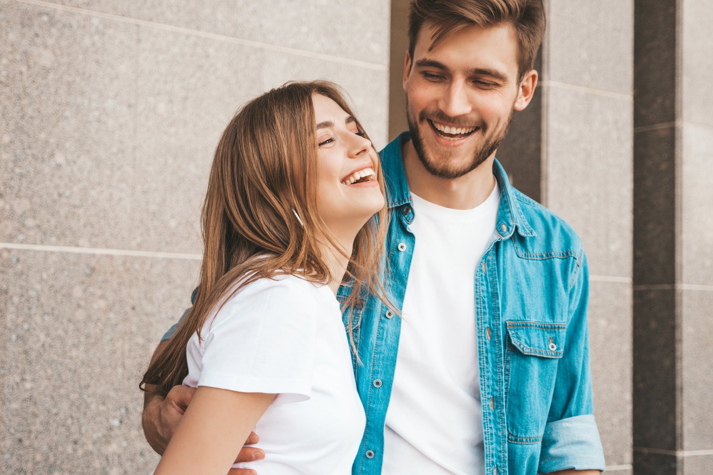 A young couple laughing together outdoors