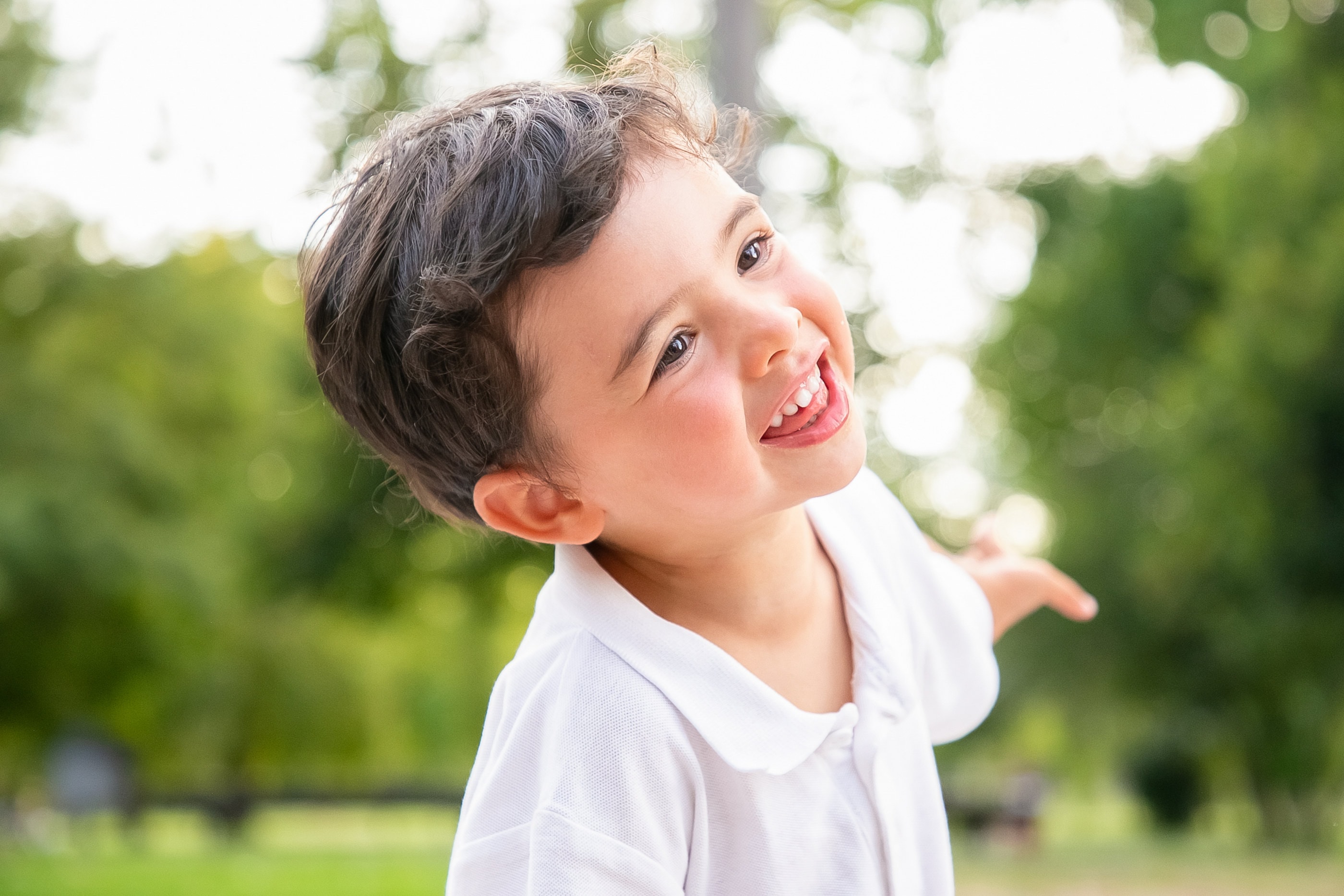 A young boy laughing and playing outdoors
