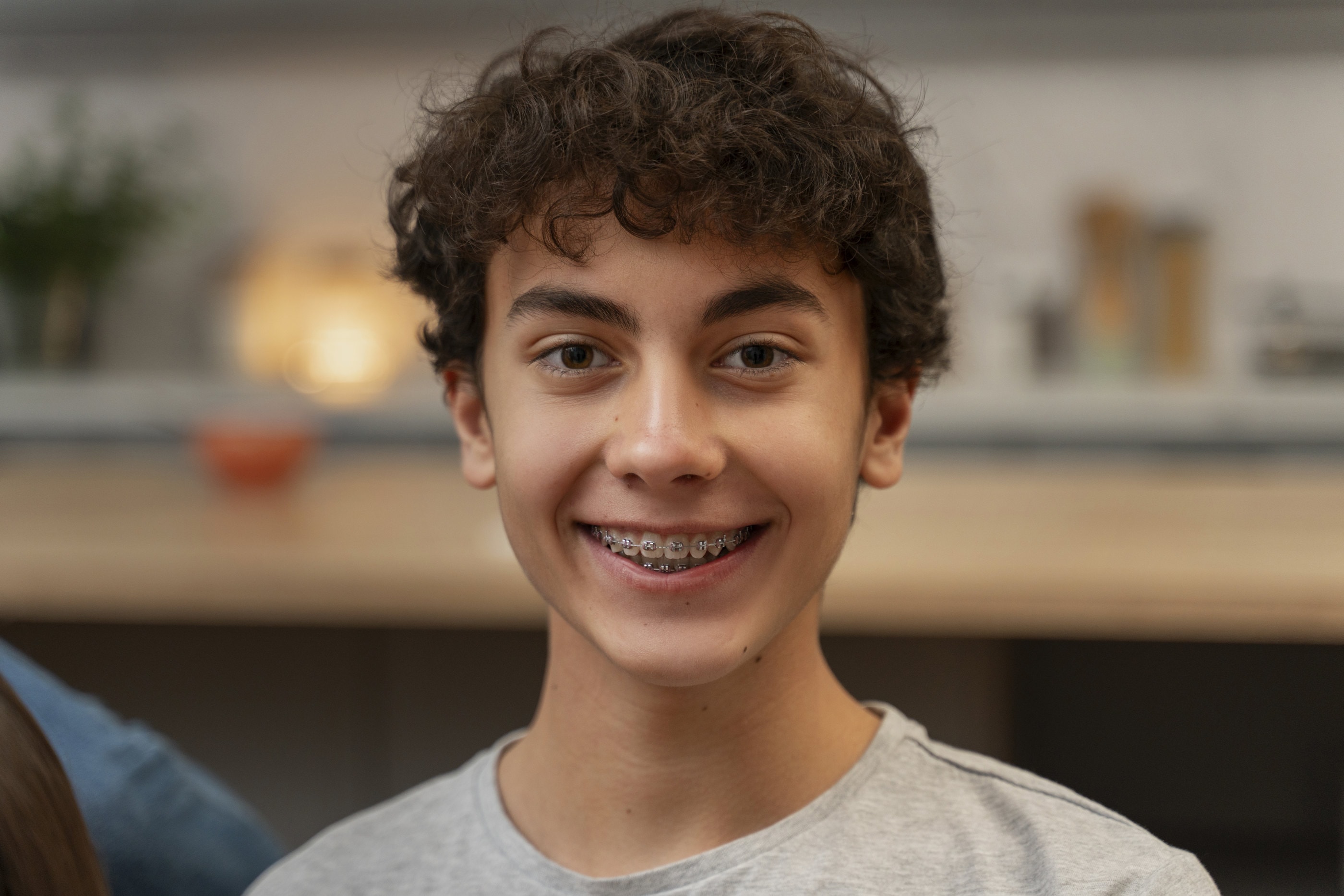 A smiling teenage boy wearing braces