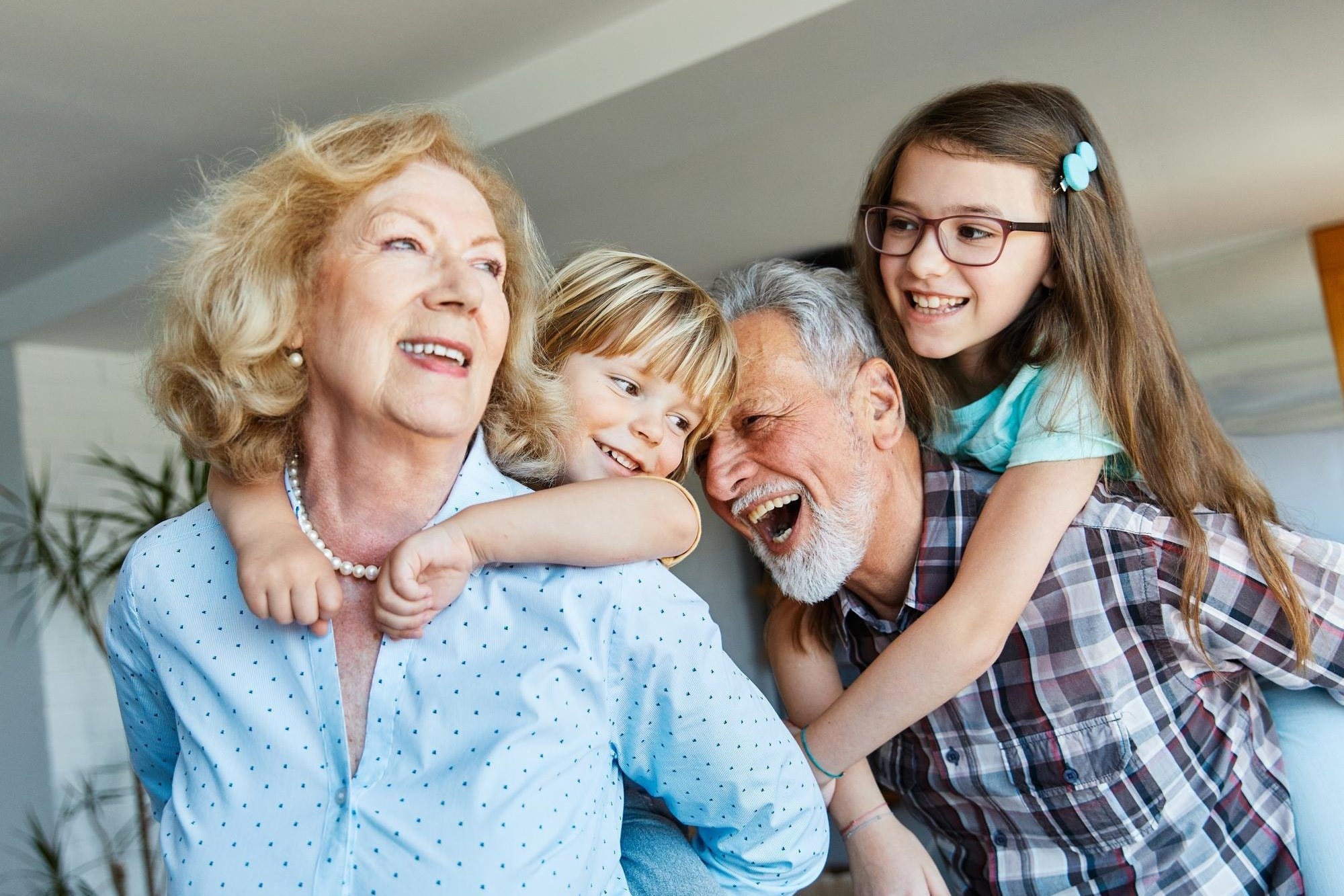 Grandparents laughing with their two grandchildren at home